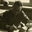 Horace Hansen working at desk at Dachau, 1945